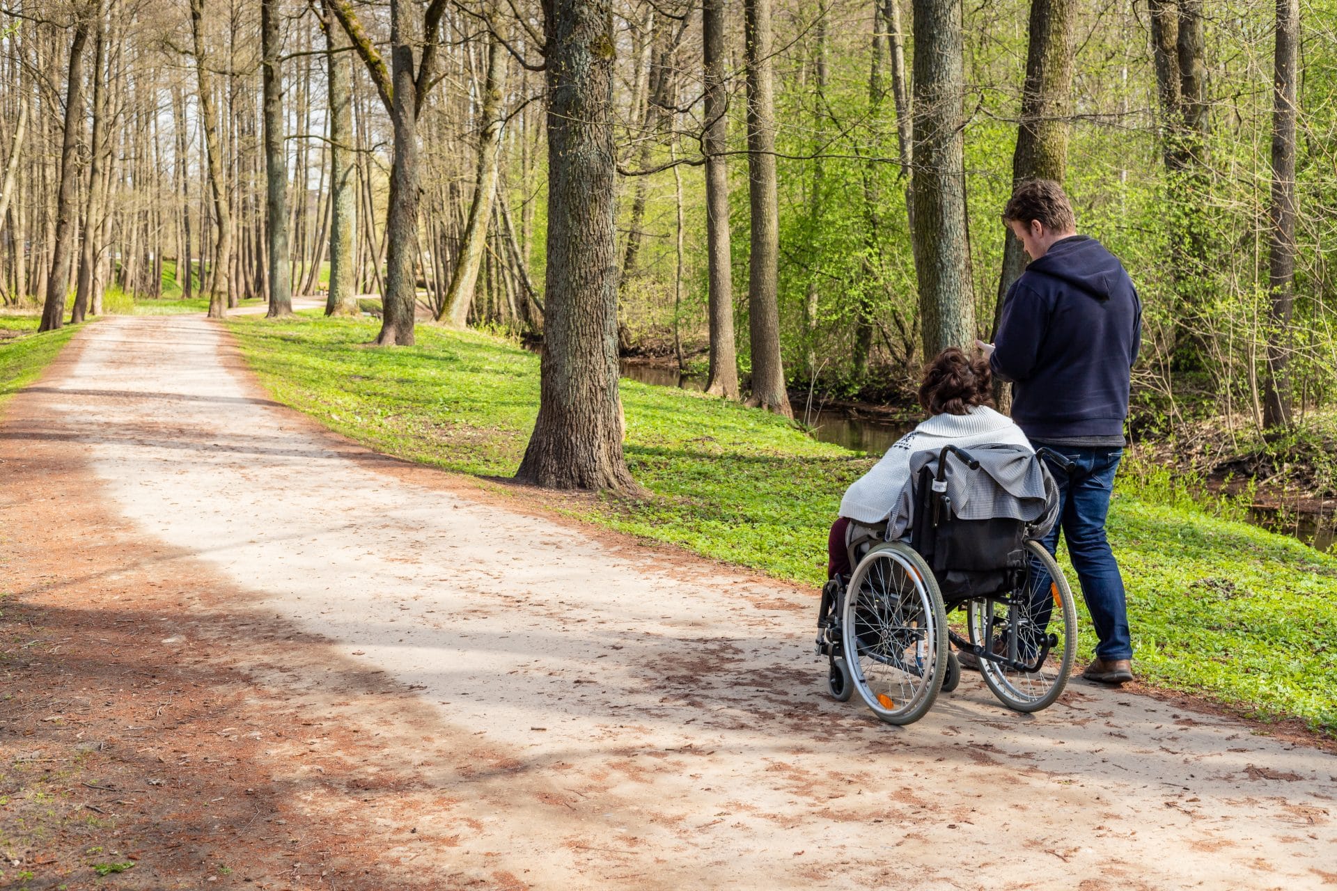 Support worker walking with a participant in a park